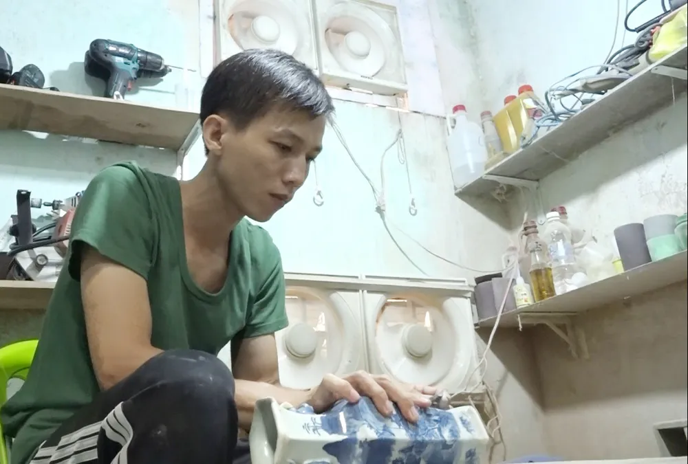 Anh Duy với món cổ vật của khách nhờ phục chế lại Anh Duy với món cổ vật của khách nhờ phục chế lại