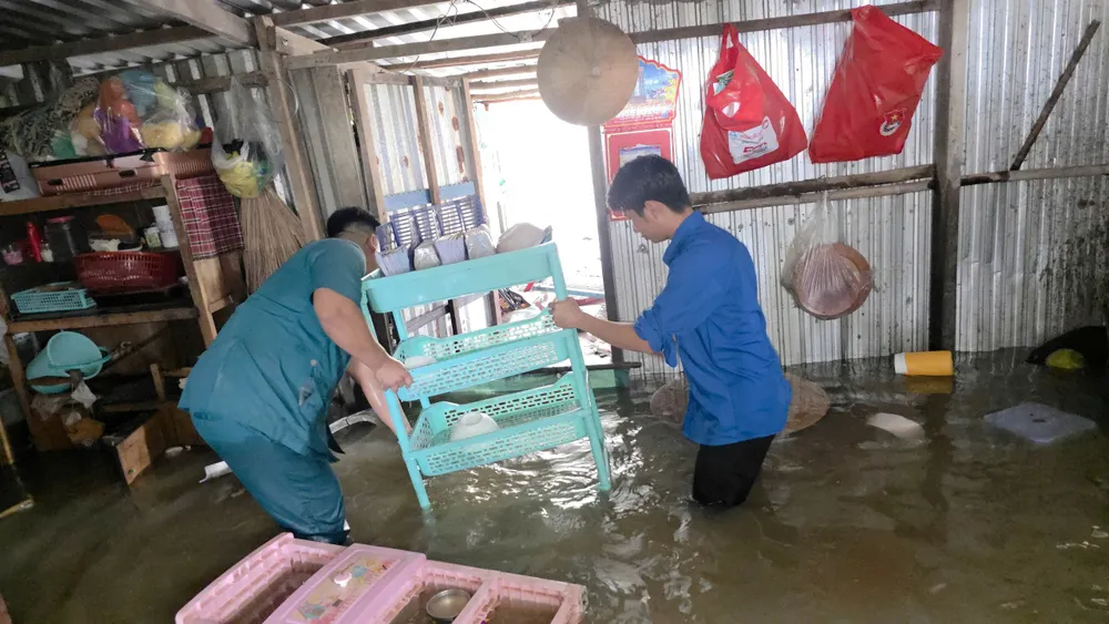 Dân quân tự vệ giúp người dân di chuyển đồ đạc tránh ngập.jpg