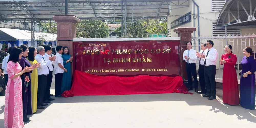 Các đại biểu thực hiện nghi thức gắn biển tên trường