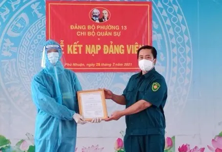 Đồng chí Lê Phú Cường, Bí thư Đảng ủy phường 13, quận Phú Nhuận trao quyết định kết nạp đảng cho đồng chí Vũ Nguyễn Hoàng Dũng