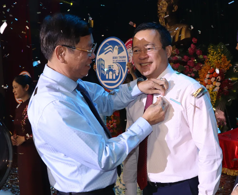 Bí thư Quận ủy quận Bình Thạnh Vũ Ngọc Tuất gắn biểu trưng của quận cho cán bộ đảng viên