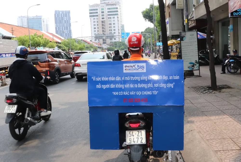 Số điện thoại thu nhận rác và khẩu hiệu tuyên truyền được ghi trên thùng xe