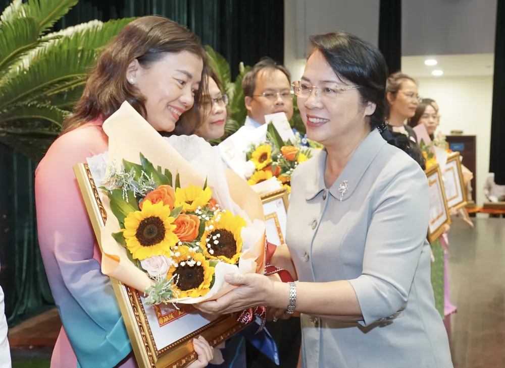 Chủ tịch Ủy ban MTTQ Việt Nam TPHCM Trần Kim Yến trao Bằng khen cho tập thể. Ảnh: HOÀNG HÙNG