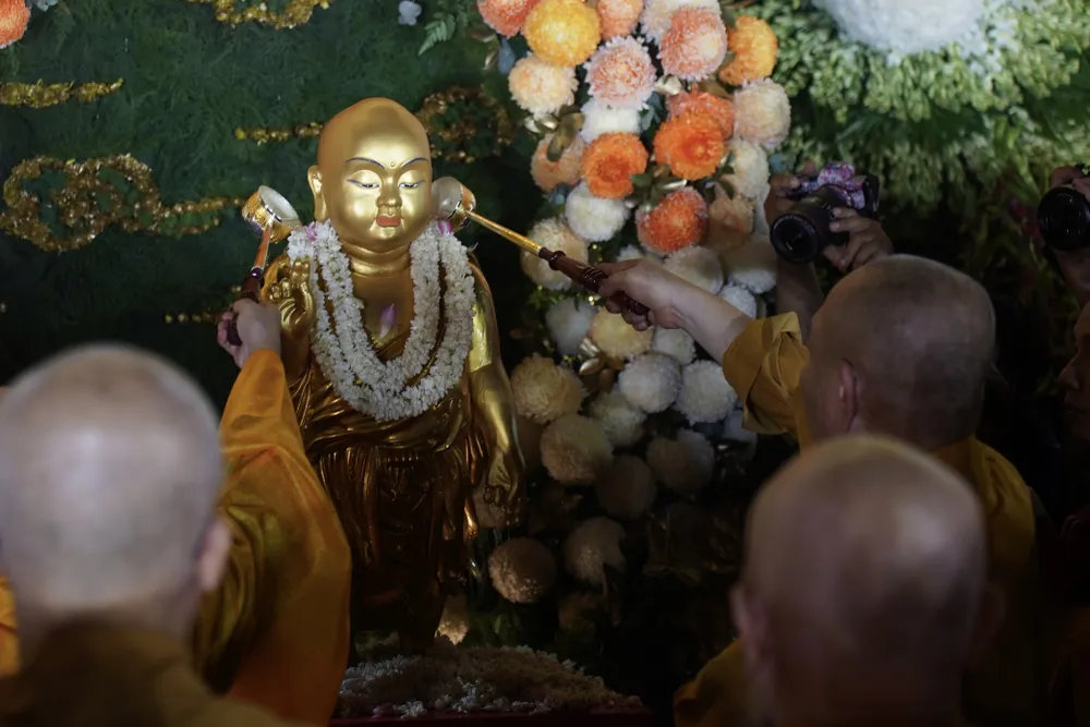 Chư tôn đức thực hiện nghi thức Lễ tắm Phật tại Việt Nam Quốc Tự. Ảnh: HOÀNG HÙNG