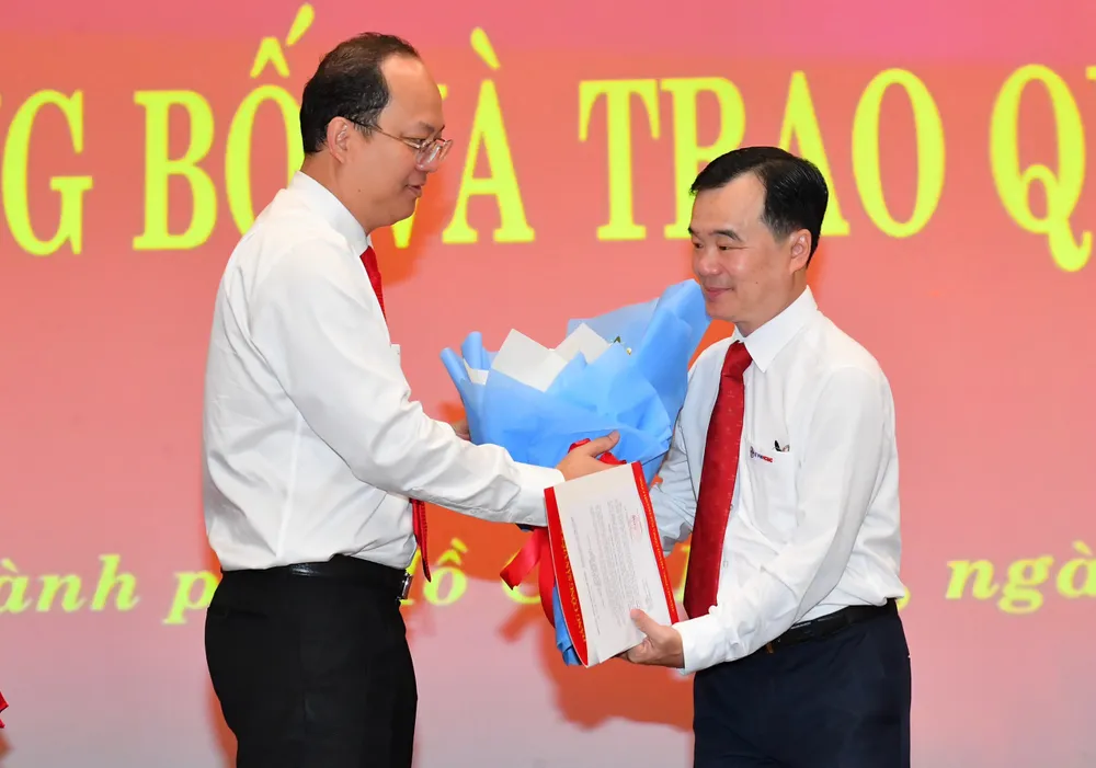 Đồng chí Nguyễn Hồ Hải trao quyết định công nhận Phó Bí thư Đảng ủy Tổng Công ty Điện lực TPHCM đối với đồng chí Trần Vũ Quang. Ảnh: VIỆT DŨNG