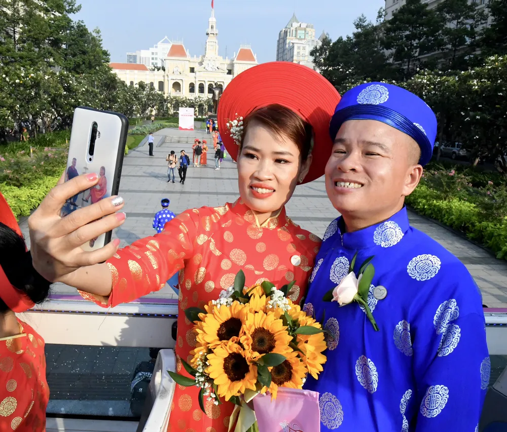 Cặp đôi tự chụp ảnh kỷ niệm khi lên xe buýt 2 tầng về nhà hàng. Ảnh: VIỆT DŨNG