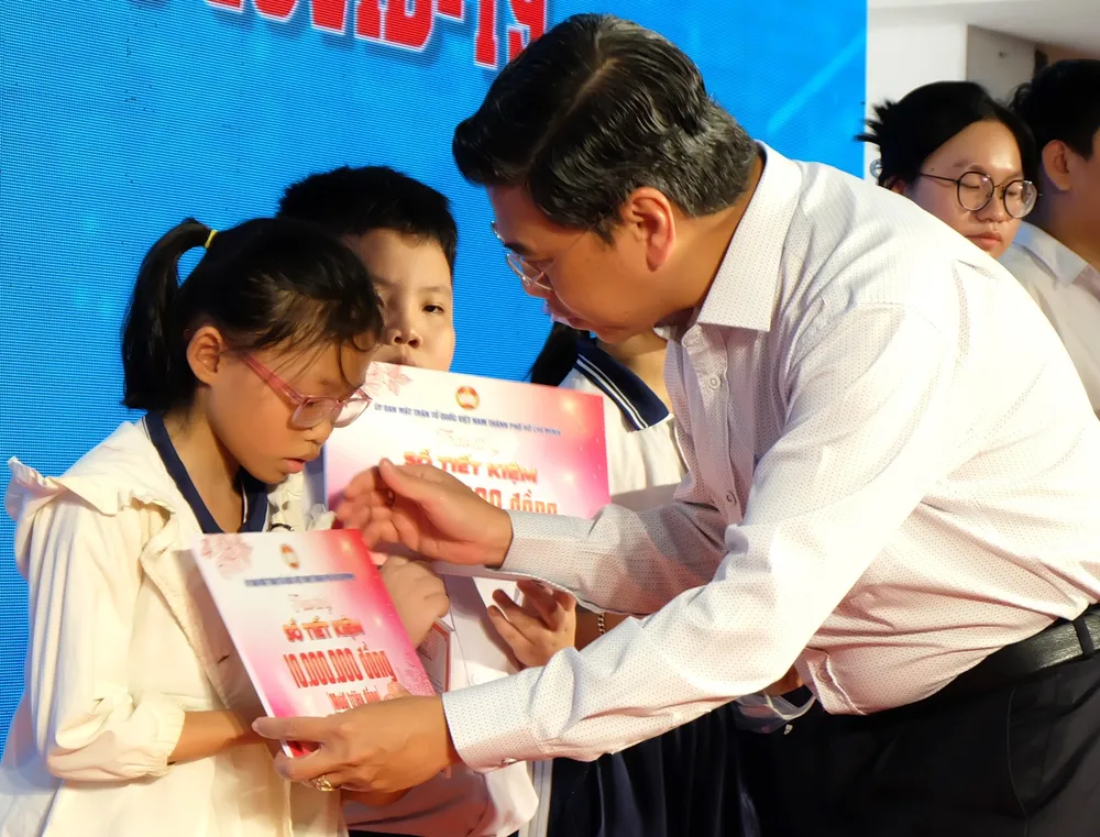 Trao sổ tiết kiệm đến trẻ mồ côi do dịch Covid-19. Ảnh: LONG HỒ