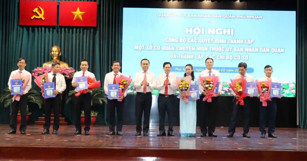 Phó Bí thư Thường trực Quận ủy quận Phú Nhuận Huỳnh Đăng Linh và Chủ tịch UBND quận Phú Nhuận Nguyễn Đông Tùng trao các quyết định thành lập một số cơ quan chuyên môn thuộc UBND quận. Ảnh THÁI PHƯƠNG