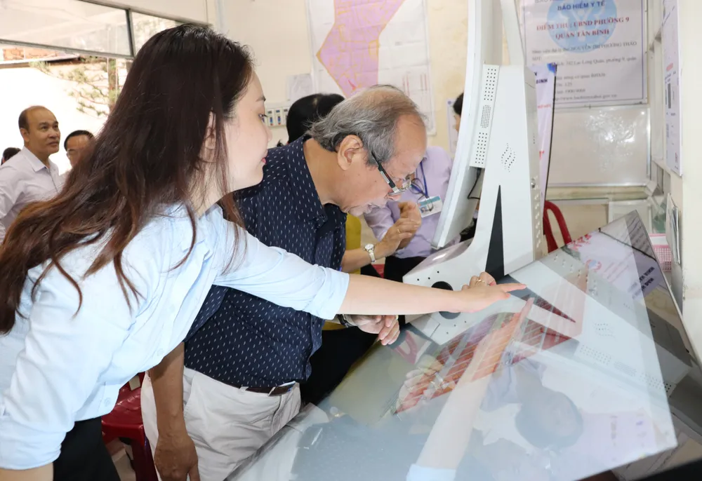 Người dân thực hiện nộp hồ sơ tại Ki-ốt Dịch vụ công đặt tại UBND phường 9, quận Tân Bình sáng 18-4