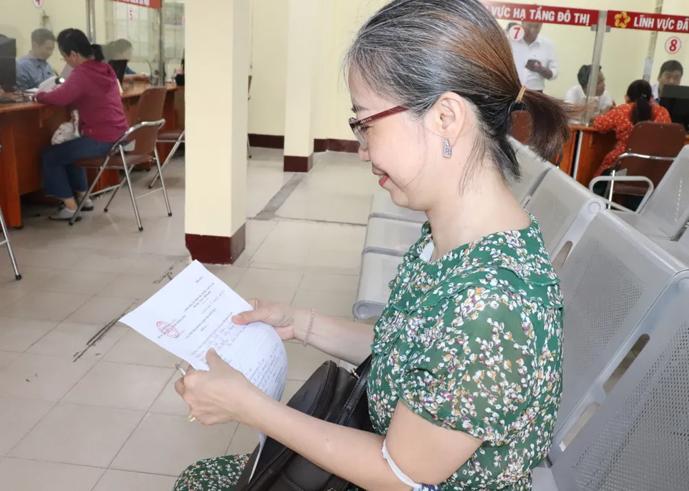 Bà Trần Tiểu Nhiên hài lòng khi chỉ 10 phút sau hồ sơ đã được cán bộ Trung tâm Phục vụ hành chính công phường Cầu Kiệu giải quyết xong. Ảnh: THÁI PHƯƠNG