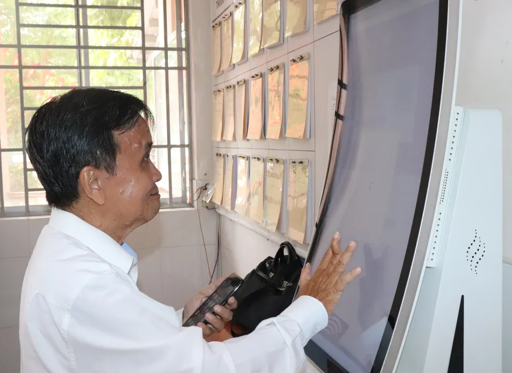 Người dân phường Tân Hòa thực hiện các thao tác tại ki-ot thông minh. Ảnh: THÁI PHƯƠNG