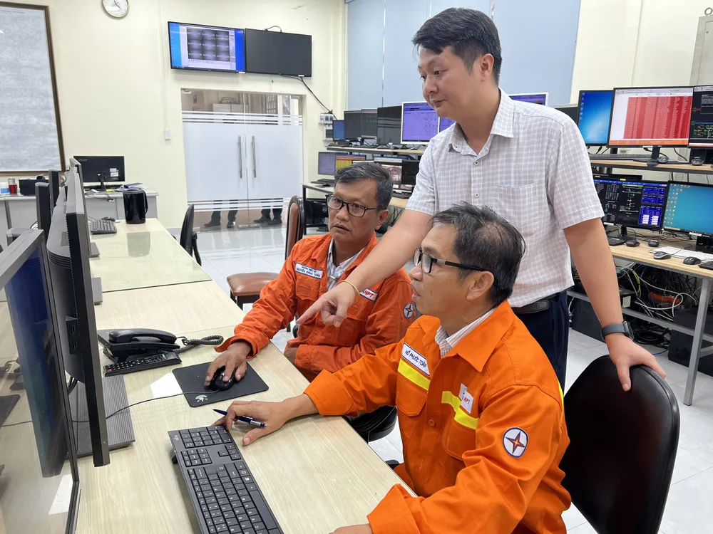 Anh Võ Sỹ Danh hướng dẫn đồng nghiệp theo dõi các thông tin lưới điện.jpg