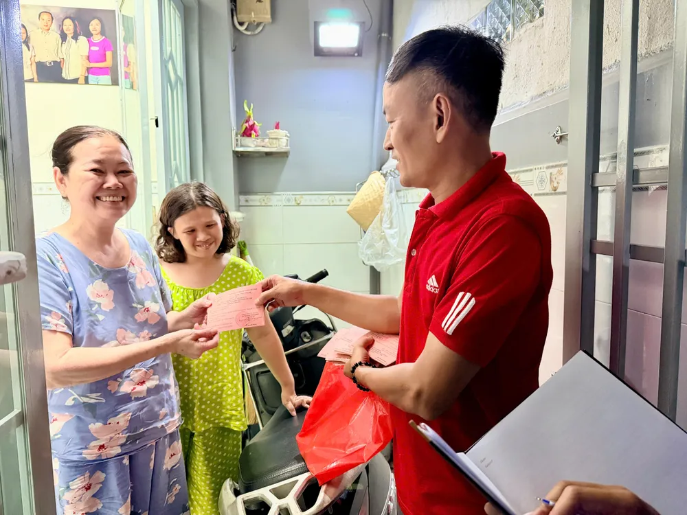 Anh Cao Cần, tổ trưởng khu phố 14, phường Khánh Hội phát phiếu bầu cử đến người dân (ẢNH HOÀNG HÙNG).jpg