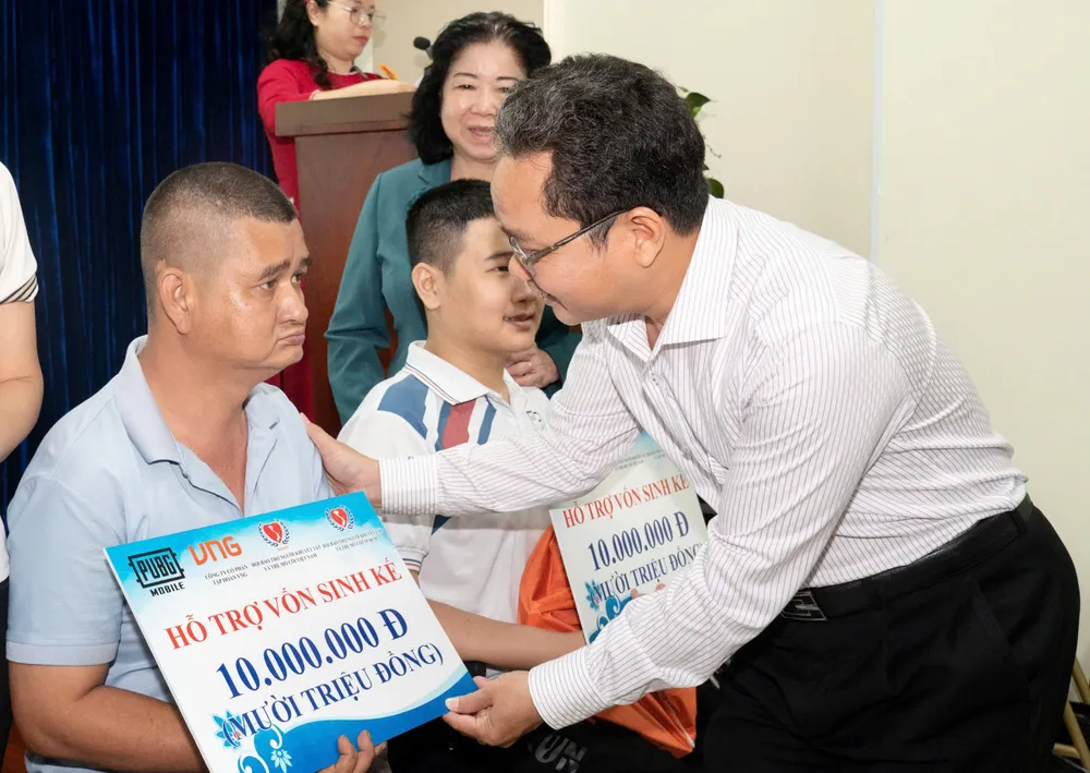 Phó Chủ tịch Ủy ban MTTQ Việt Nam TPHCM Phạm Minh Tuấn trao hỗ trợ sinh kế đến người khuyết tật khó khăn. Ảnh: QUỐC THANH