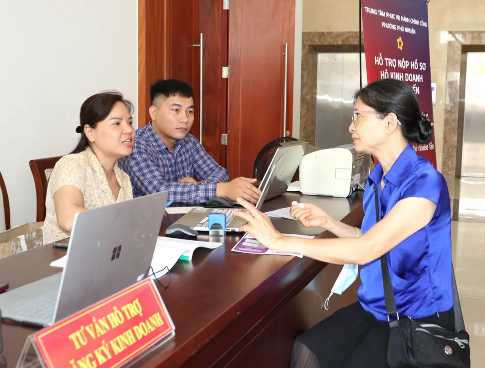 Tư vấn người dân đăng ký hộ kinh doanh tại ngày hội. Ảnh: THÁI PHƯƠNG