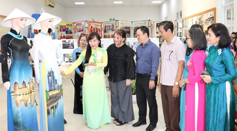 Bà Trịnh Thị Thanh giới thiệu về chiếc áo dài truyền thống Việt Nam đến bà Palina Karpava, Phó Tổng Lãnh sự Belarus tại TPHCM. Ảnh: THÁI PHƯƠNG