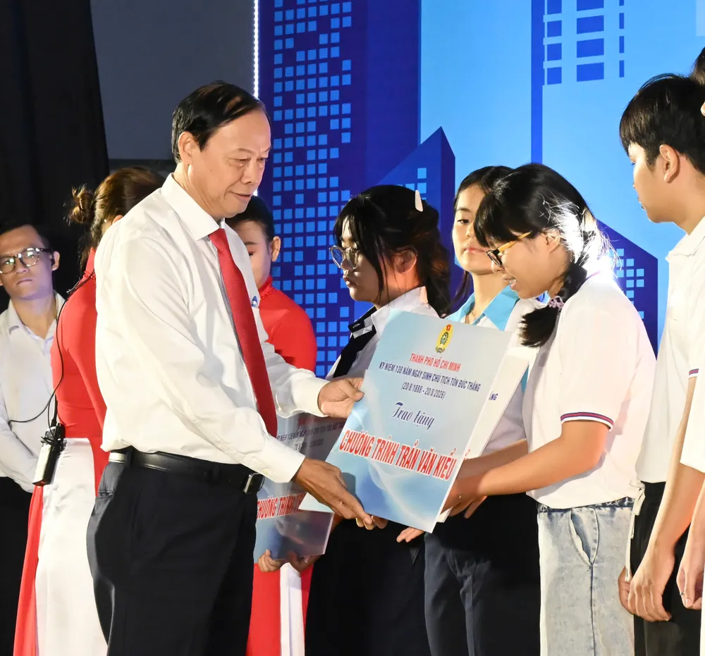 Phó Chủ tịch Thường trực HĐND TPHCM Nguyễn Văn Thọ trao hỗ trợ từ Chương trình Trần Văn Kiểu đến con công nhân hiếu học. Ảnh: VIỆT DŨNG