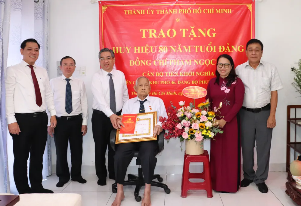 Phó Bí thư Thành ủy TPHCM Nguyễn Phước Lộc trao Huy hiệu 80 năm tuổi Đảng đến đồng chí Phạm Ngọc Ẩn. Ảnh: THÁI PHƯƠNG