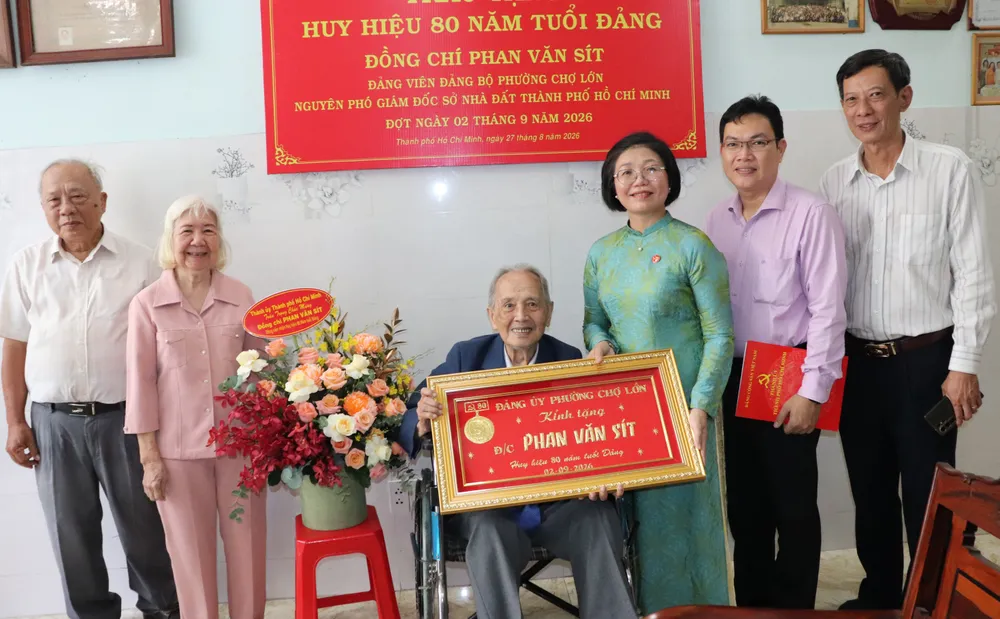 Đại diện phường Chợ Lớn và chi bộ khu phố chúc mừng đồng chí Phan Văn sít nhận Huy hiệu 80 năm tuổi Đảng. Ảnh: THÁI PHƯƠNG
