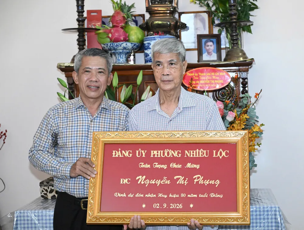 Thông qua người thân trong gia đình, lãnh đạo phường Nhiêu Lộc chúc mừng đến đồng chí Nguyễn Thị Phụng. Ảnh: VIỆT DŨNG