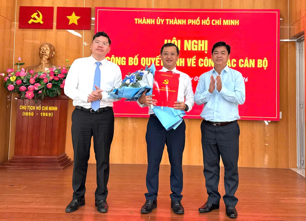 Đồng chí Hoàng Nguyên Dinh và đồng chí Lê Văn Minh trao quyết định, tặng hoa chúc mừng đồng chí Tạ Quốc Trung. Ảnh: THÁI PHƯƠNG