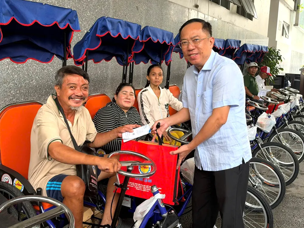 Niềm vui của người khuyết tật khi nhận xe lắc tay. Ảnh: HỒNG HẢI