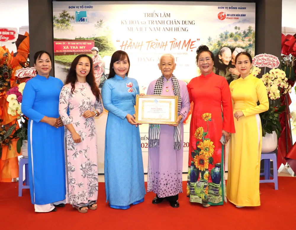 Bà Trịnh Thị Thanh, Phó Chủ tịch Thường trực Hội LHPN TPHCM, trao Bằng khen đến họa sĩ Đặng Ái Việt. Ảnh: THÁI PHƯƠNG