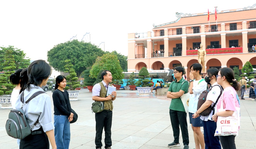 阮俊英老师(手捧书)与学生们参观芽龙码头。