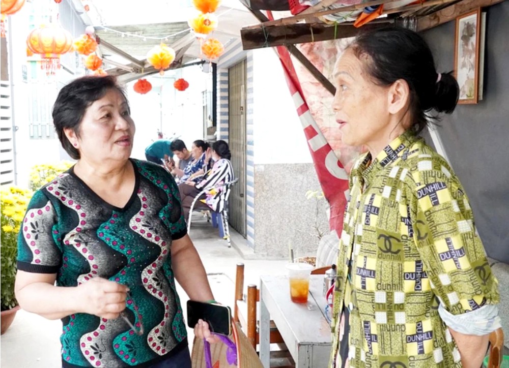 阮氏心党支书（左）探访街区里的民众。