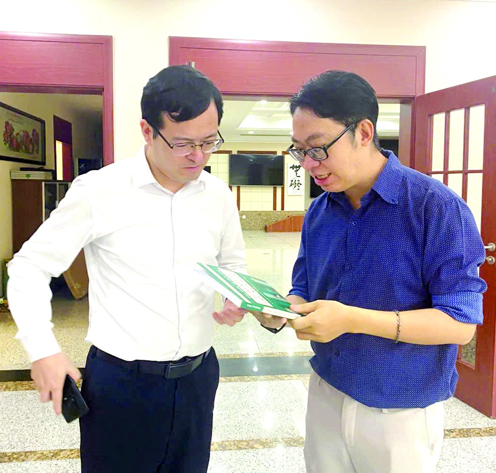 中国语文系副主任张家权博士向中国驻胡志明市总领馆副总领事徐州赠送《中国经济》一书。