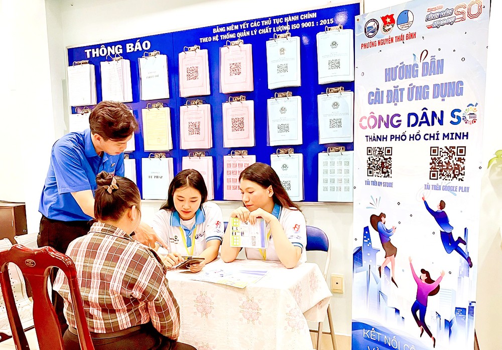 志愿者在第一郡阮太平坊人委会指引居民安装市数位公民应用程式。