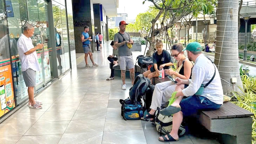 游客在第四郡第九坊云屯街River Gate 公寓大楼等候领取住房钥匙入住（尽管这里有禁止短期入住的标志）。