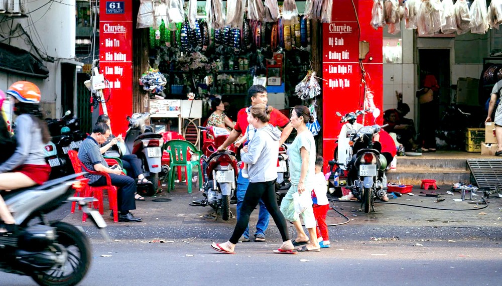 由于人行道被占用作为修车处，所以行人须在街上行走。