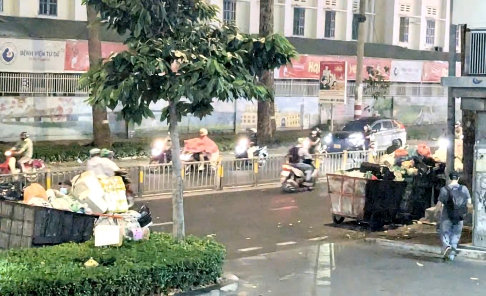 垃圾收集车停在第三郡阮氏明开街《西贡解放报》报社大楼入口两侧。