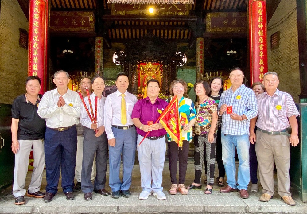 穗城会馆副理事长陈志豪将圣母令旗郑重移交予粤剧团顾问会会长丁文森后合照。