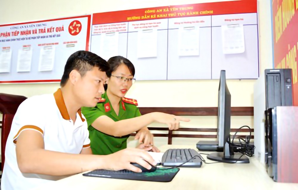 乡公安干部指引民众在国家公共服务网页办理行政手续。