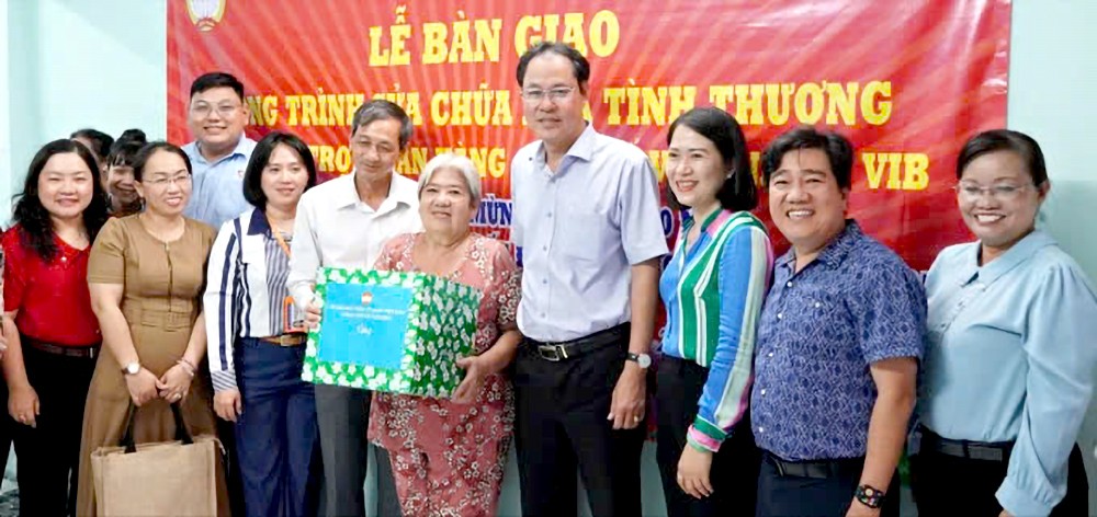 市越南祖国阵线委员会代表向第八郡居民移交温情屋。