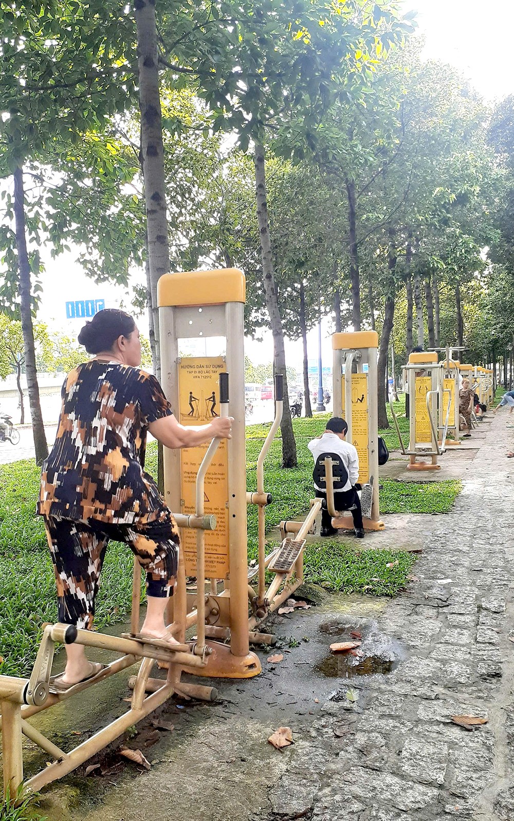 人们在公园里的树荫下做运动会更加起劲。