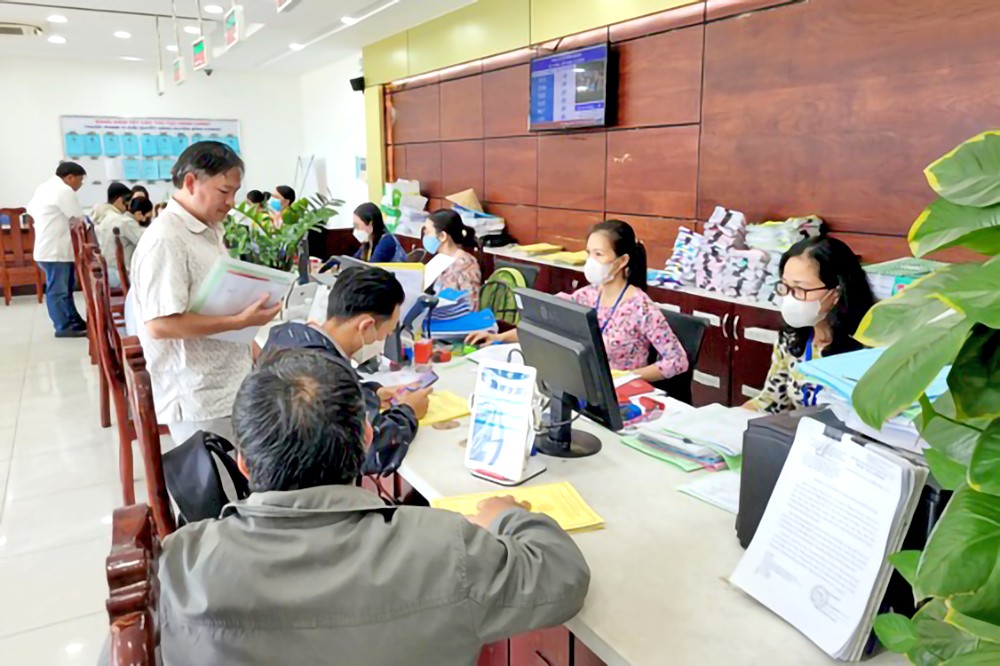 取消郡县级模式，增加坊乡级的权限，将有助于政府更接近人民，减少中间环节，更好地为人民服务。图为胡志明市干部、公务员为市民解决行政手续。