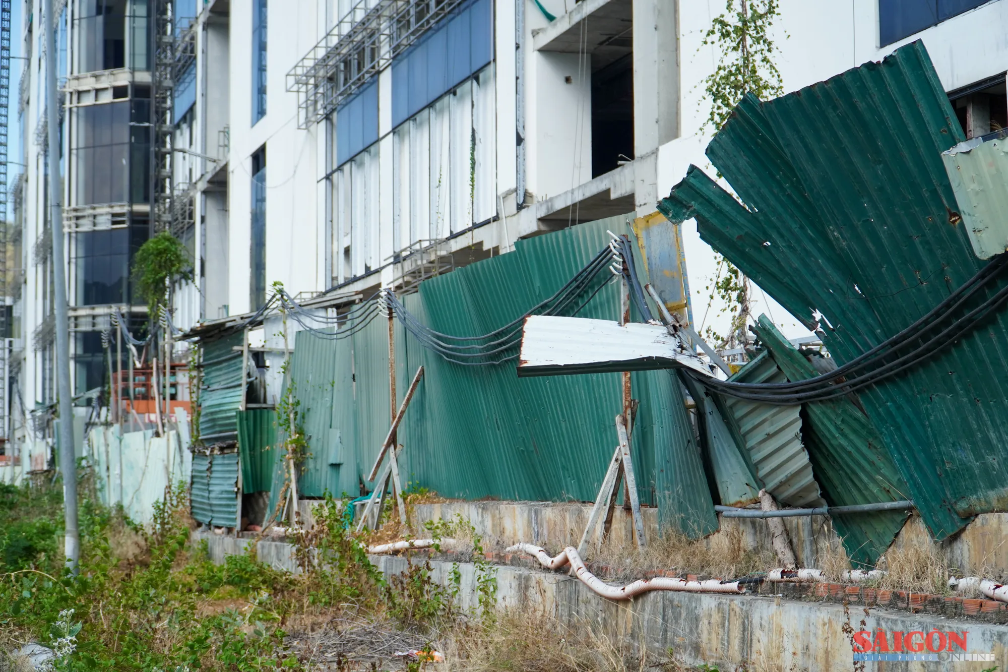 Rào chắn xung quanh dự án xiêu vẹo, cỏ mọc um tùm. Ảnh: HIẾU GIANG anh3.jpg
