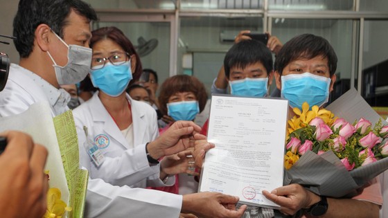 Bác sĩ Nguyễn Tri Thức, Giám đốc BV Chợ Rẫy trao giấy xuất viện cho ông Li Ding, người Trung Quốc, bị nhiễm Covid-19, được điều trị thành công. Ảnh: HOÀNG HÙNG