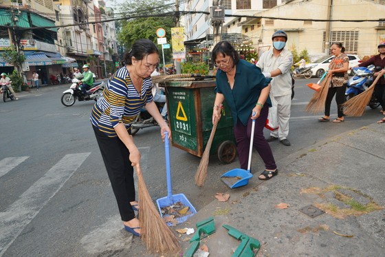 Người dân tham gia quét dọn rác trên đường phố. Ảnh: VIỆT DŨNG
