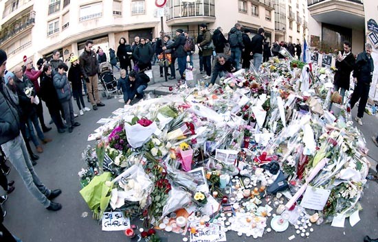 Người dân Pháp đặt hoa tưởng niệm các nạn nhân gần trụ sở Tạp chí Charlie Hebdo, sau khi vụ tấn công khủng bố xảy ra năm 2015