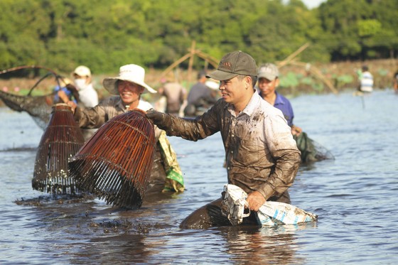 Hàng trăm người reo hò, lội bùn bắt cá cầu may  ảnh 7