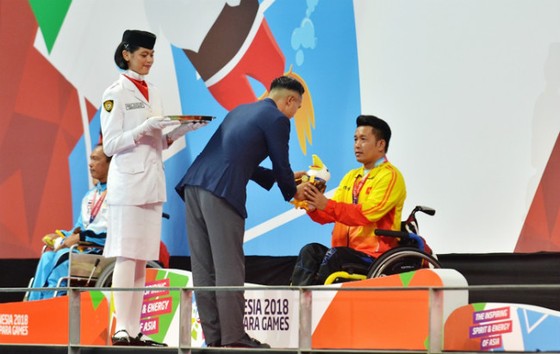 VĐV Nguyễn Thành Trung đón nhận tấm HCV 100m ếch nam.