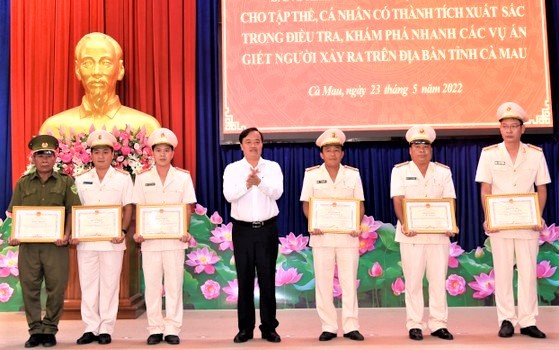 Ông Huỳnh Quốc Việt (thứ 4, từ trái sang) tặng bằng khen cho các cá nhân có thành tích điều tra khám phá nhanh các vụ trọng án
