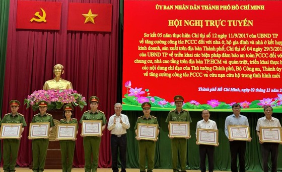 Phó Chủ tịch UBND TPHCM Ngô Minh Châu trao bằng khen cho các cá nhân, tập thể có thành tích xuất sắc. Ảnh: CHÍ THẠCH