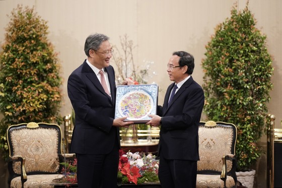 Đồng chí Nguyễn Văn Nên, Ủy viên Bộ Chính trị, Bí thư Thành ủy nhận quà lưu niệm của Bộ trưởng Bộ Thương mại Trung Quốc (Ảnh: Hoàng Hùng)