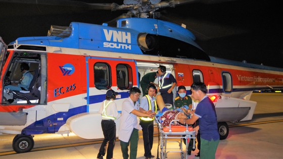 Lực lượng nhân viên y tế và nhân viên sân bay vận chuyển bệnh nhân từ trực thăng về bệnh viện
