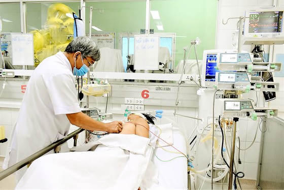 Bác sĩ chăm sóc bệnh nhân đang điều trị sốc sốt xuất huyết tại Bệnh viện Bệnh Nhiệt đới TPHCM